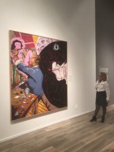 Woman standing in front of artwork in museum gallery space