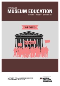 JME's 47.4 cover image. A large group of people stand outside of a museum that has multiple columns and a decorated pediment. Above the museum are the words, "We Need," and below it is the word, "Change".